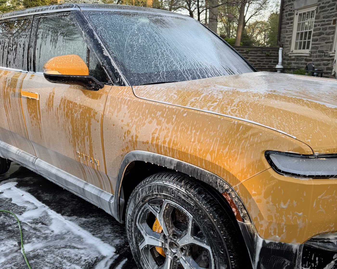 Rivian R1S under foam during the wash